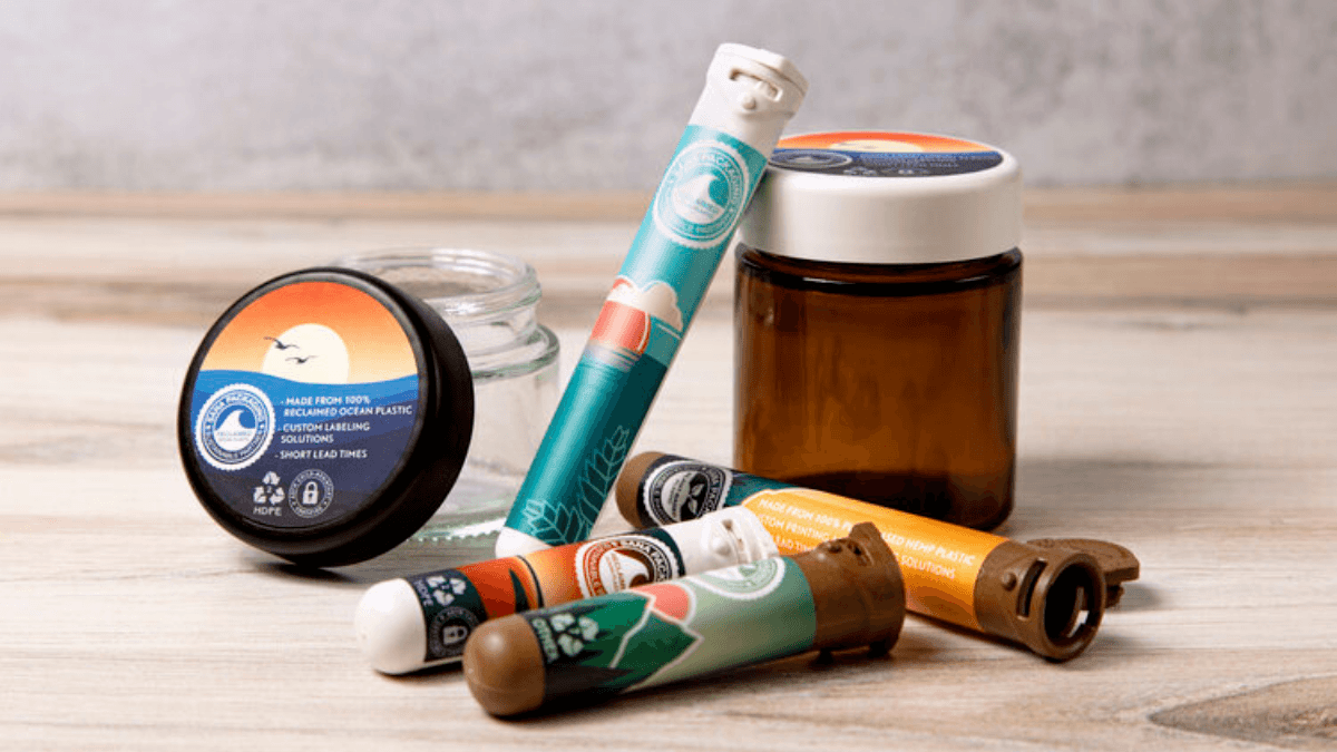 A collection of hemp plastic packagiing and packaging made from ocean plastic, designed for cannabis and hemp products, including jars and "doob tubes."